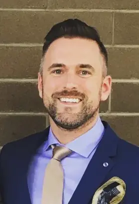Dr. Andrew Bass, Vancouver dentist at The Vital Smile, smiling in a suit and tie